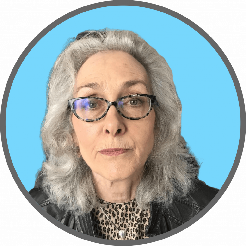 A casual profile photo of Juliet. She has silvery-grey hair and tortoise coloured glasses. She wears a leopard print shirt with a leather-styled jacket on top. he background is a bright, pastel blue.